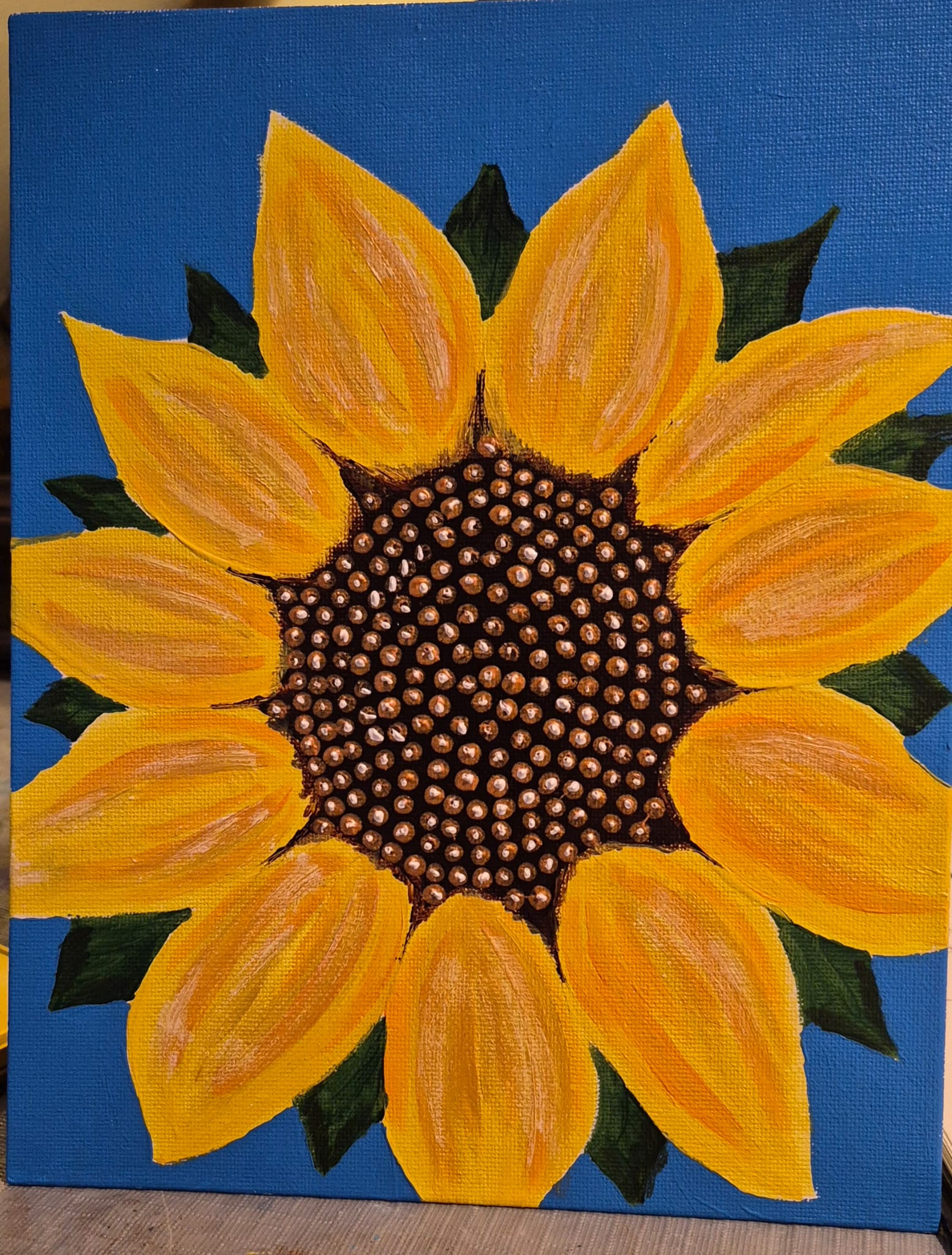 Painting of a bright bold yellow sunflower on a blue background